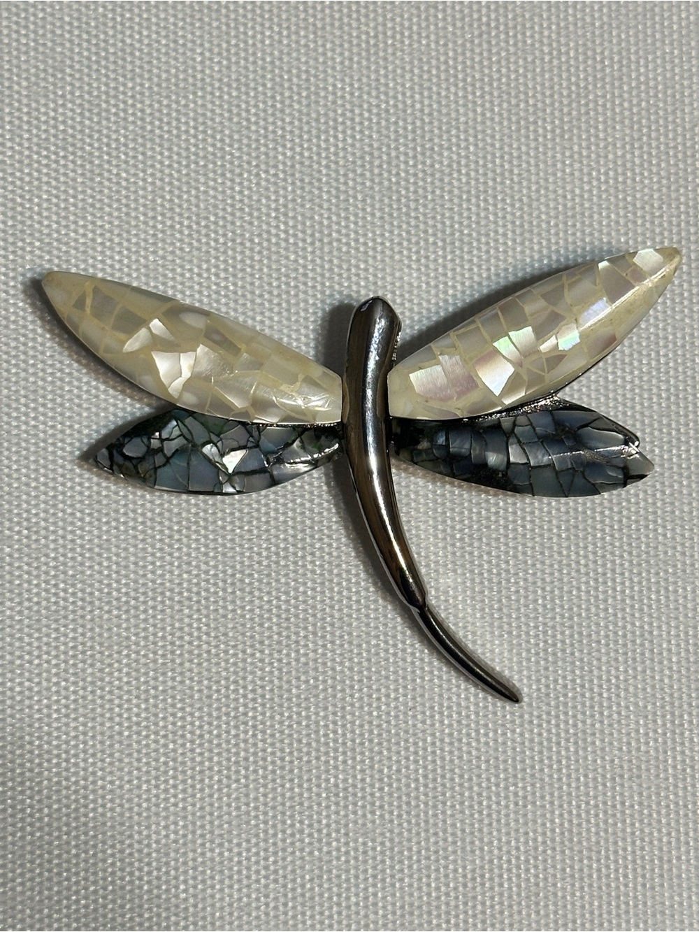 Vintage dragonfly brooch featuring a sleek silver-tone or chromed metal